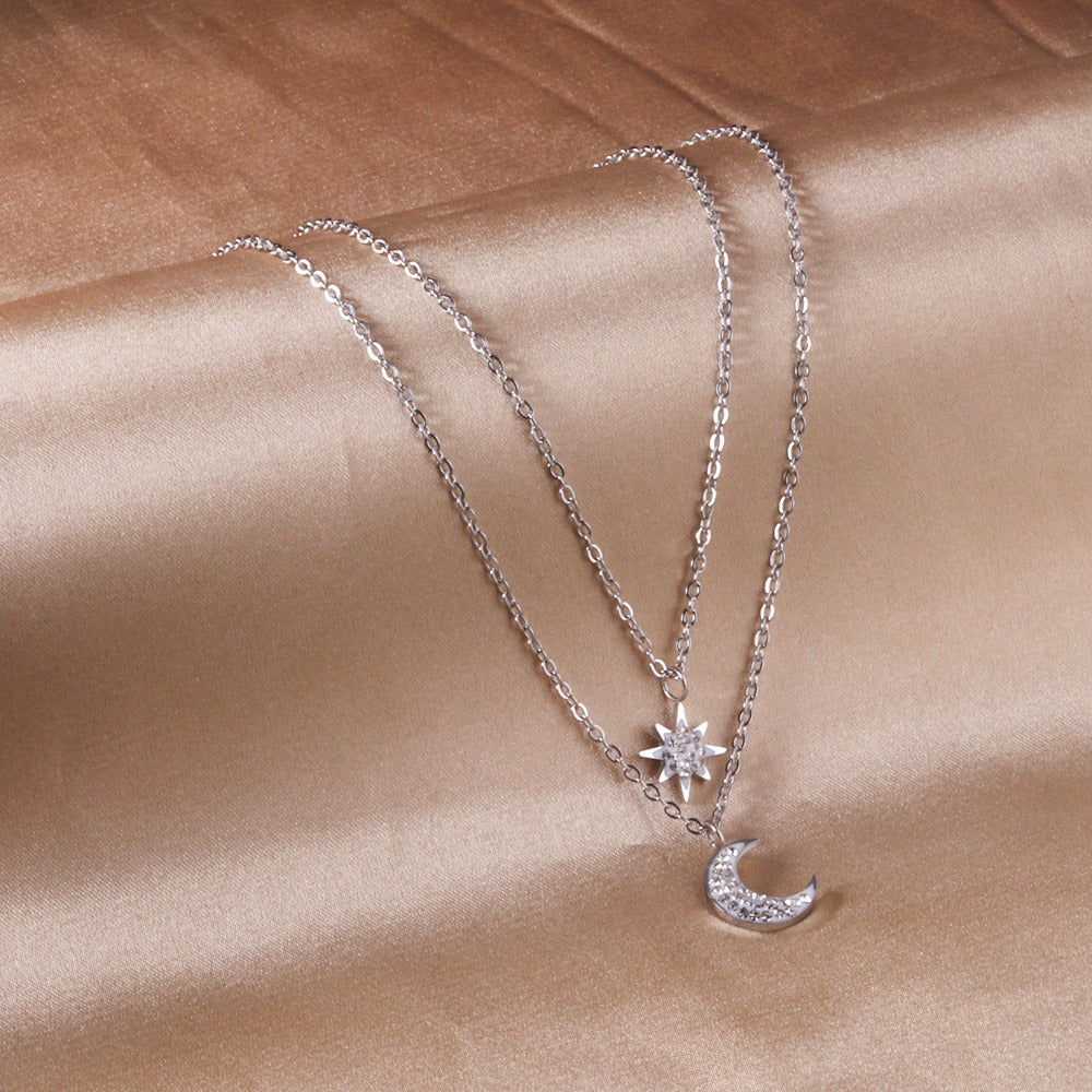 Double layered silver necklace with moon pendant in inner chain and star pendant in outer chain