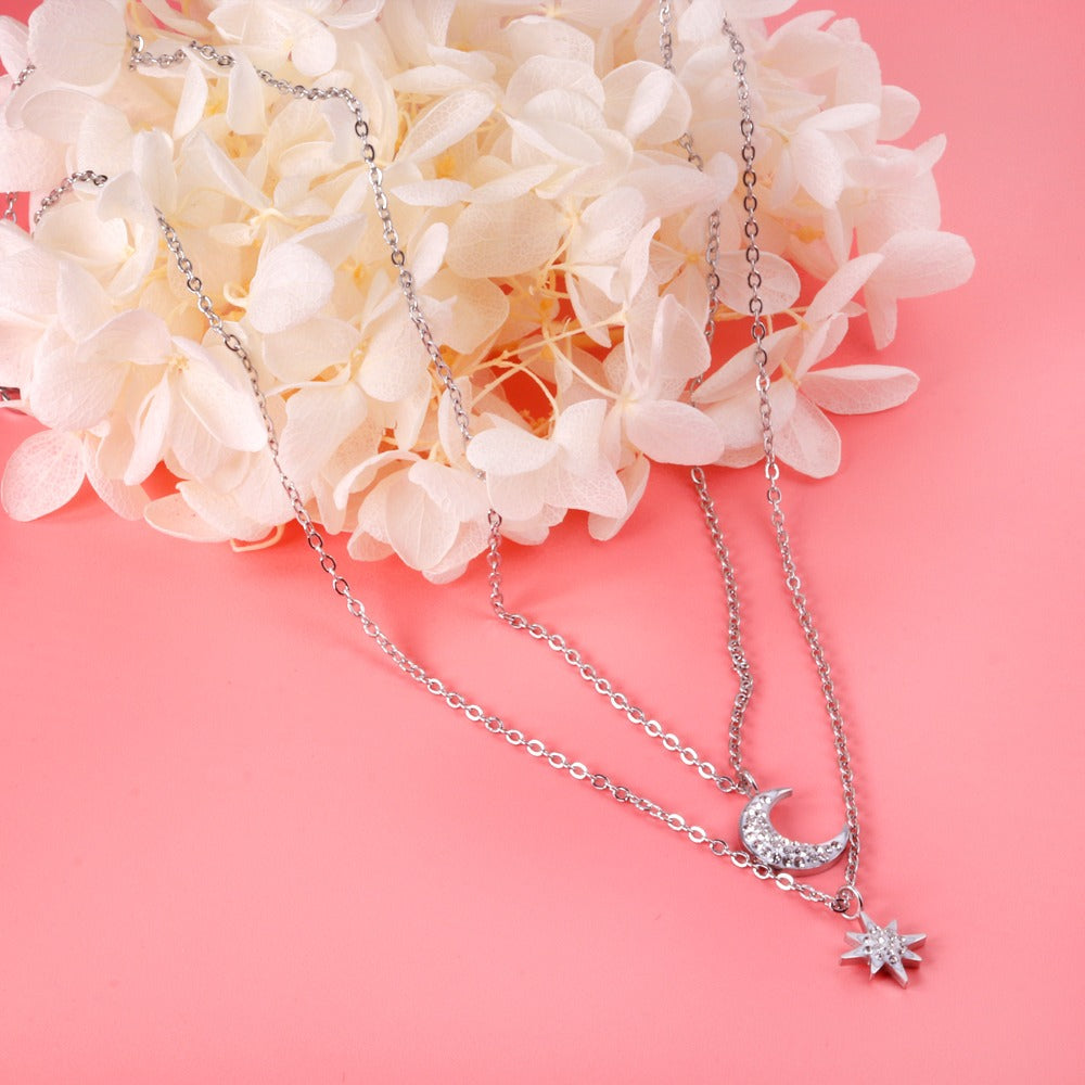 Double layered silver necklace with moon pendant in inner chain and star pendant in outer chain