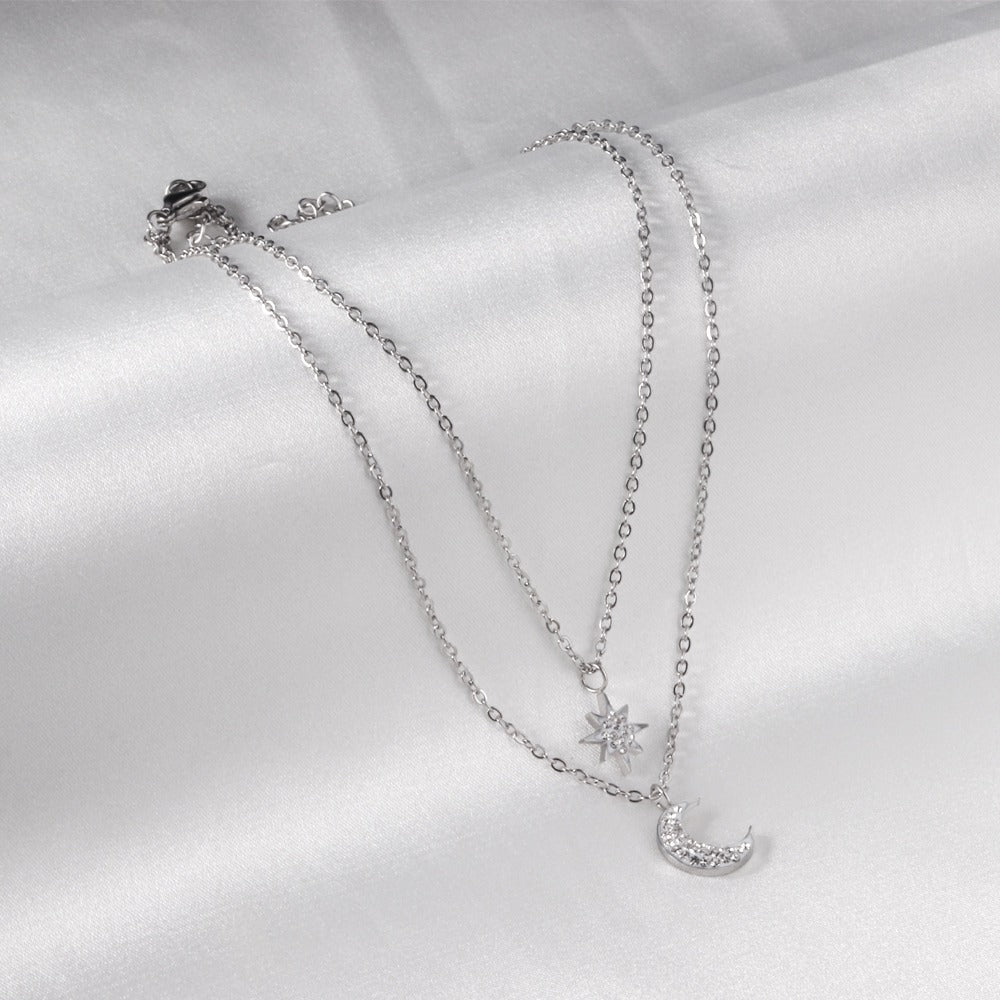 Double layered silver necklace with moon pendant in inner chain and star pendant in outer chain