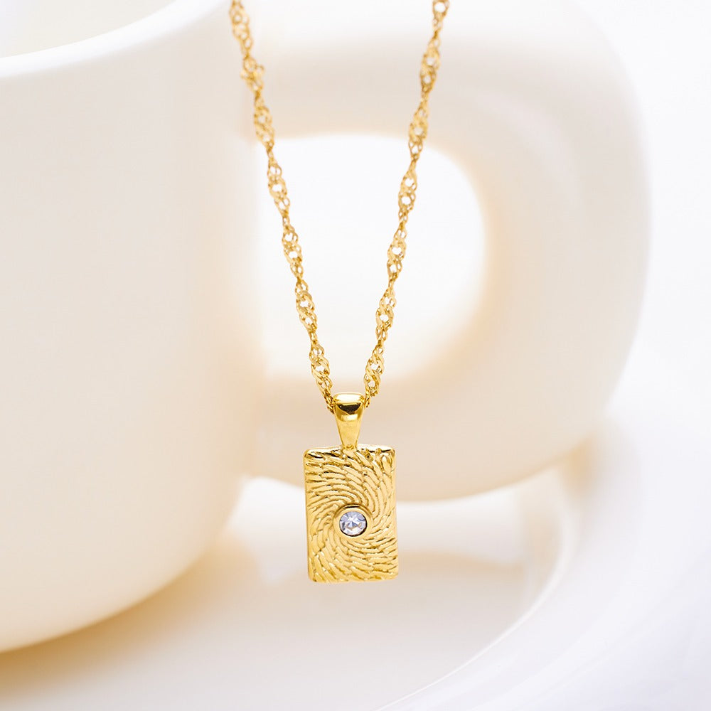 Necklace with rectangular pendant and a stone at the middle.