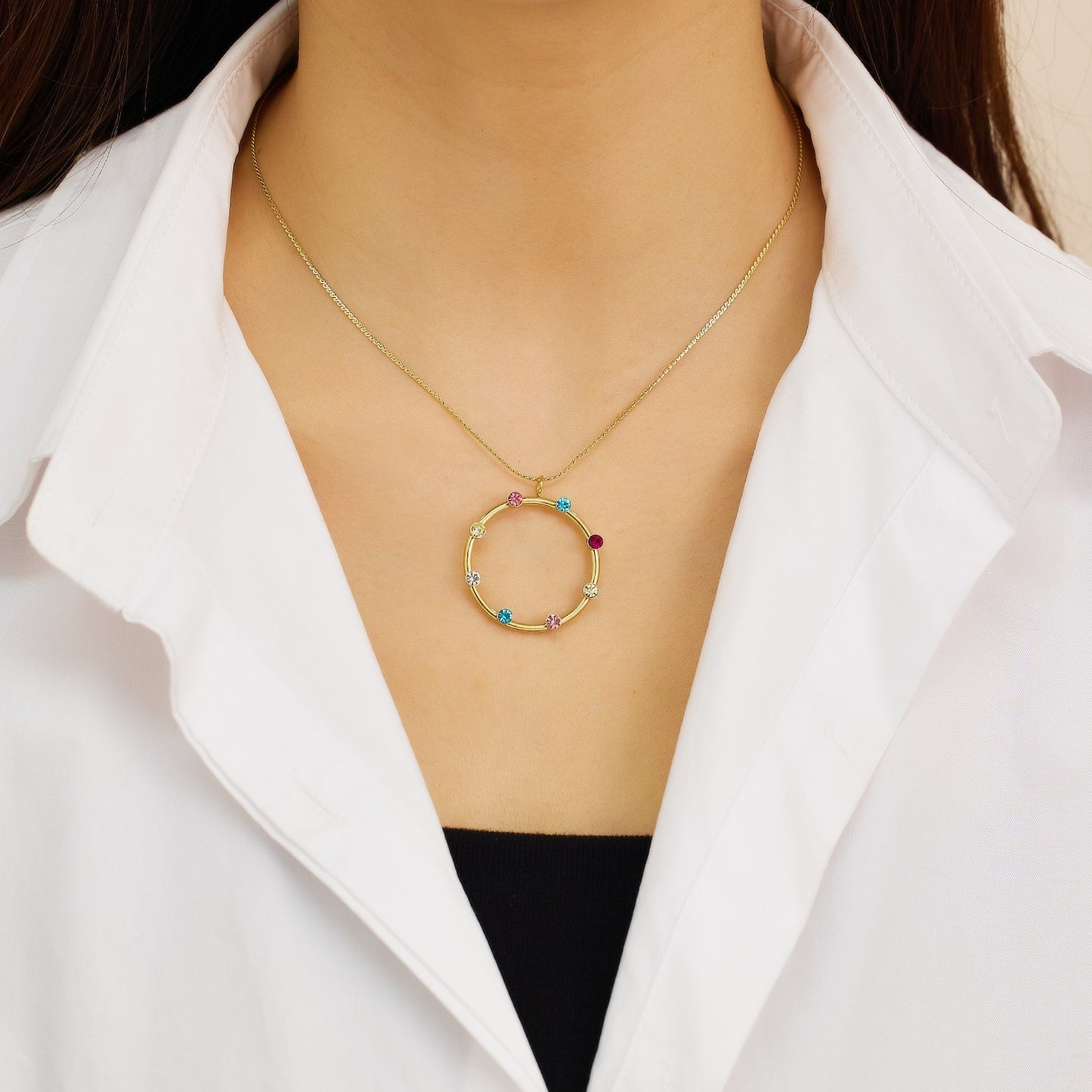 Necklace with a circle shaped pendant with various color stones