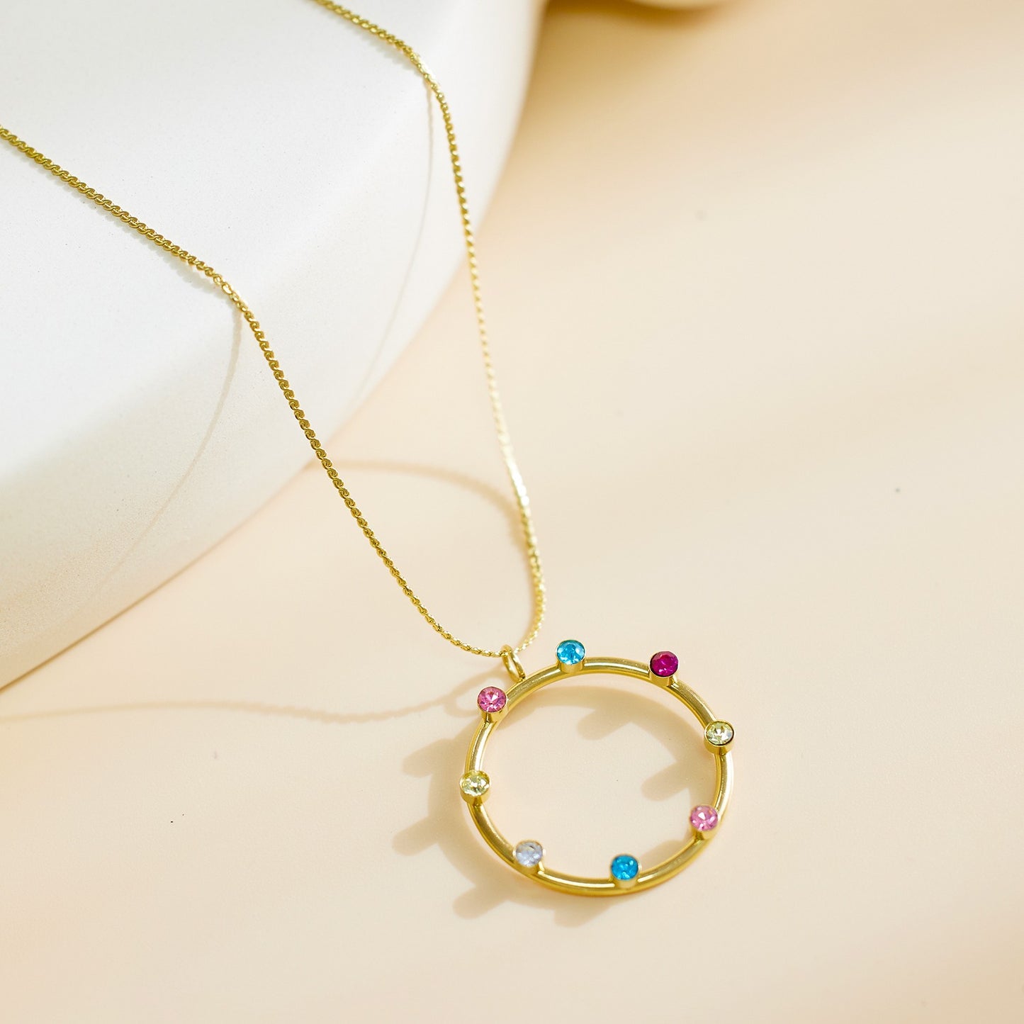Necklace with a circle shaped pendant with various color stones